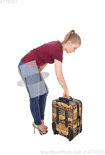 Image of Woman bending down for her suitcase