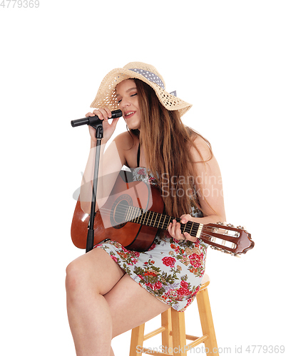 Image of Woman playing the guitar and singing