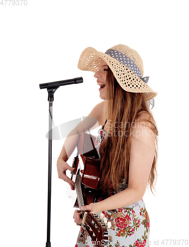 Image of Woman playing guitar and singing