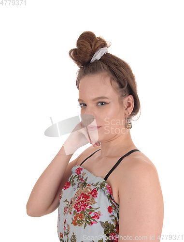 Image of Young woman in dress and bun hair