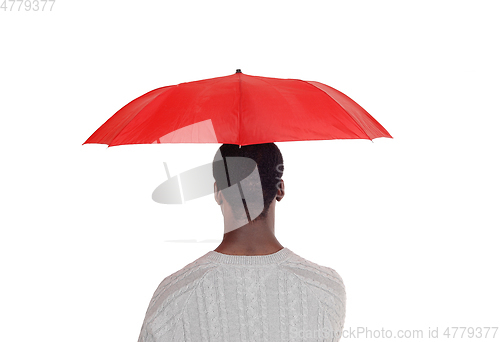 Image of Black man standing from back with red umbrella