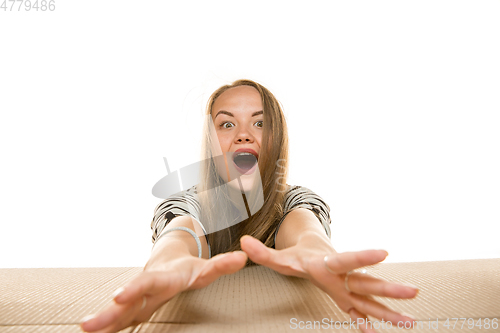 Image of Young woman opening the biggest postal package isolated on white