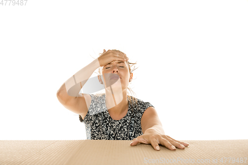 Image of Young woman opening the biggest postal package isolated on white