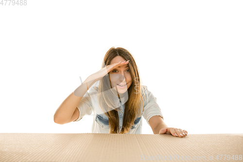 Image of Young woman opening the biggest postal package isolated on white