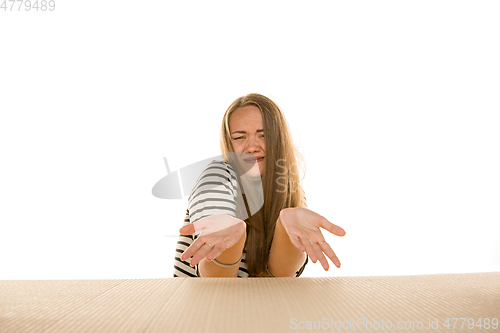 Image of Young woman opening the biggest postal package isolated on white