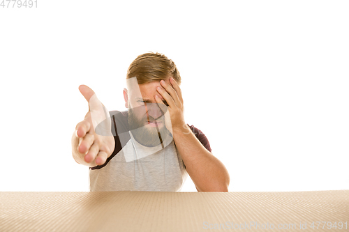 Image of Young man opening the biggest postal package isolated on white