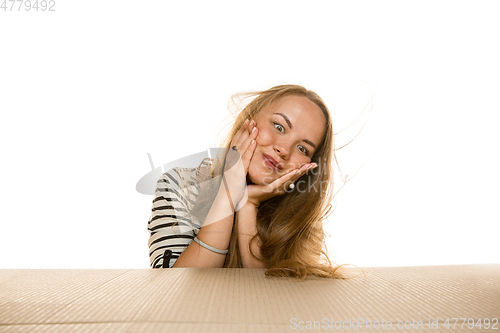 Image of Young woman opening the biggest postal package isolated on white