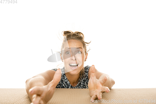 Image of Young woman opening the biggest postal package isolated on white