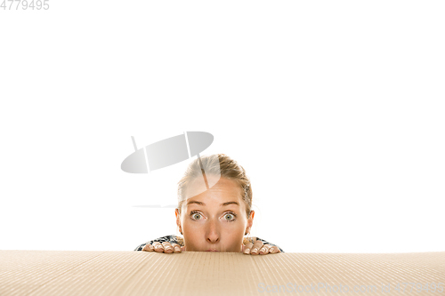 Image of Young woman opening the biggest postal package isolated on white