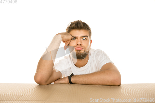 Image of Young man opening the biggest postal package isolated on white