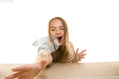 Image of Young woman opening the biggest postal package isolated on white