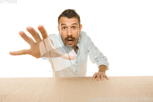 Image of Young man opening the biggest postal package isolated on white