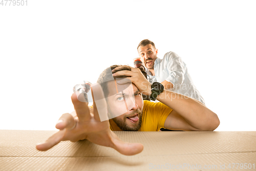 Image of Young man opening the biggest postal package isolated on white