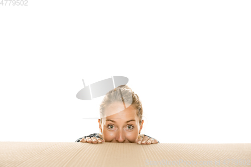 Image of Young woman opening the biggest postal package isolated on white