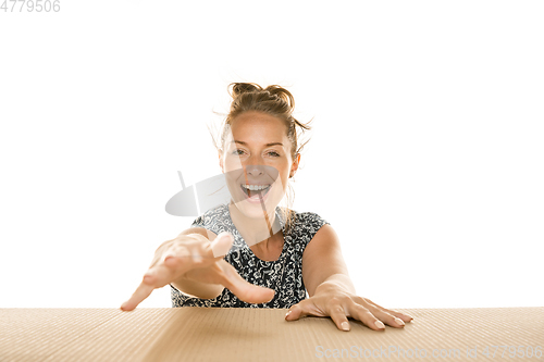 Image of Young woman opening the biggest postal package isolated on white