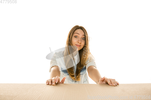 Image of Young woman opening the biggest postal package isolated on white