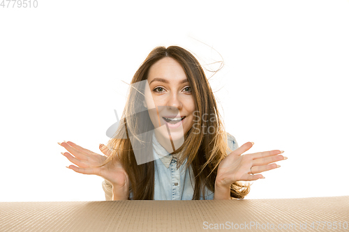 Image of Young woman opening the biggest postal package isolated on white