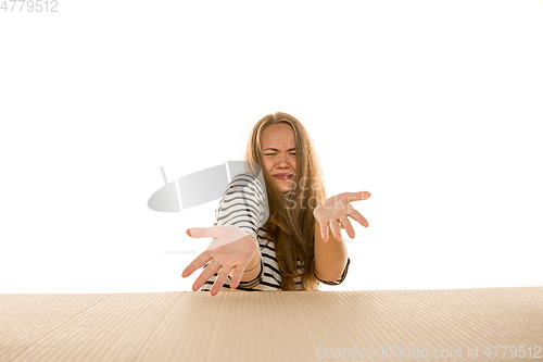 Image of Young woman opening the biggest postal package isolated on white