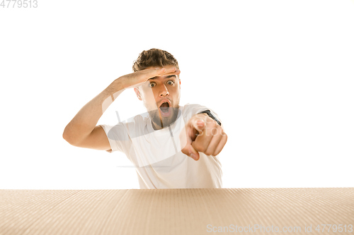 Image of Young man opening the biggest postal package isolated on white