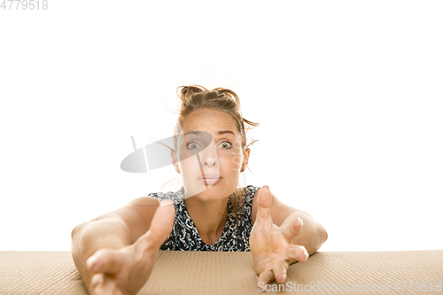 Image of Young woman opening the biggest postal package isolated on white