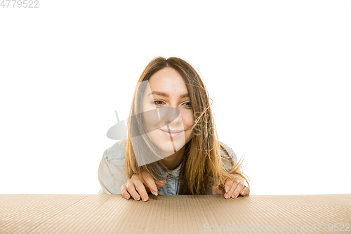 Image of Young woman opening the biggest postal package isolated on white