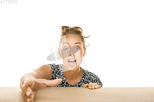 Image of Young woman opening the biggest postal package isolated on white