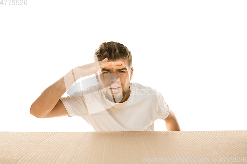 Image of Young man opening the biggest postal package isolated on white