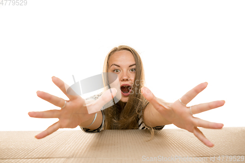 Image of Young woman opening the biggest postal package isolated on white