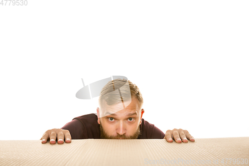 Image of Young man opening the biggest postal package isolated on white