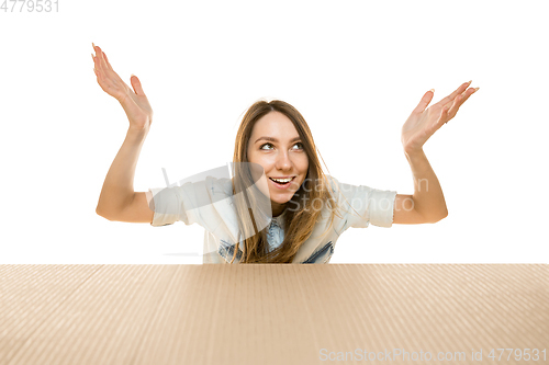 Image of Young woman opening the biggest postal package isolated on white