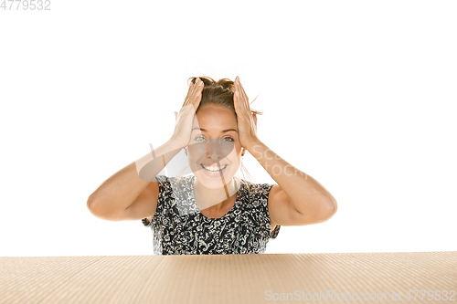 Image of Young woman opening the biggest postal package isolated on white