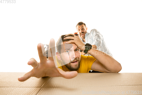 Image of Young man opening the biggest postal package isolated on white