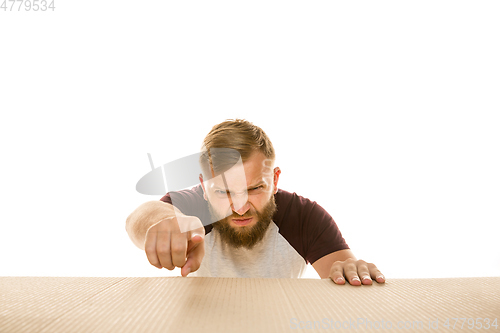 Image of Young man opening the biggest postal package isolated on white