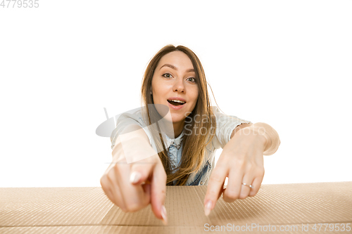 Image of Young woman opening the biggest postal package isolated on white