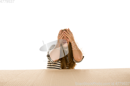 Image of Young woman opening the biggest postal package isolated on white