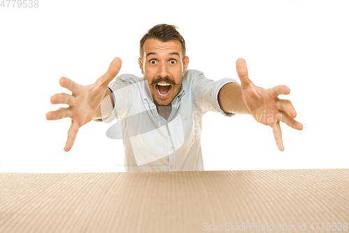 Image of Young man opening the biggest postal package isolated on white