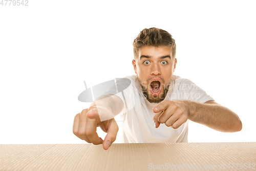 Image of Young man opening the biggest postal package isolated on white