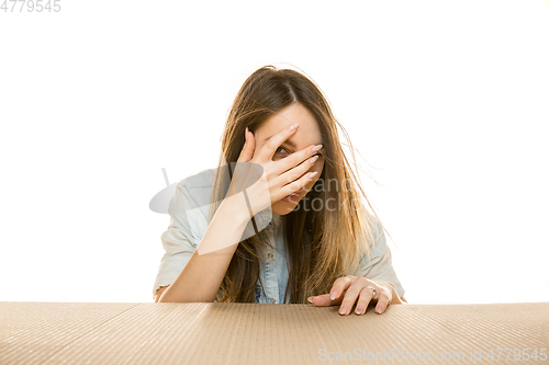 Image of Young woman opening the biggest postal package isolated on white