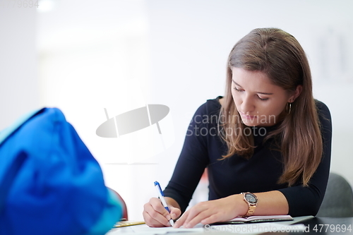 Image of student taking notes for school class