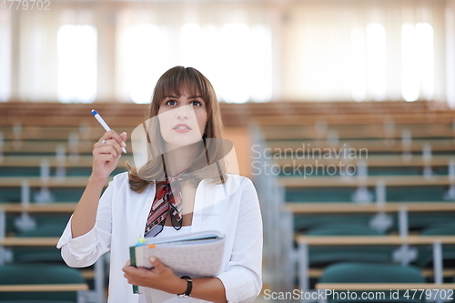 Image of famale student using pen and notebook