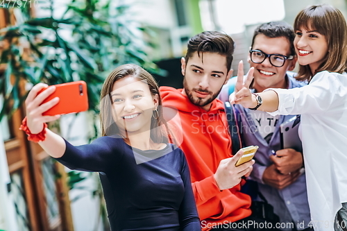 Image of Group of multiethnic teenagers taking a selfie in school