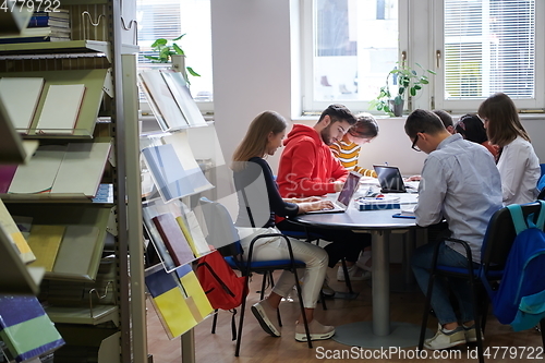 Image of students group working on school project together on tablet computer at modern university