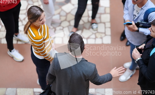 Image of students communication with professor in school corridor