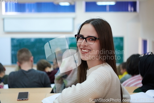 Image of girl sitting in an amphitheater and talking to her colleagues