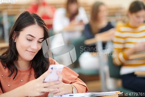 Image of famel students using smartphone in classroom