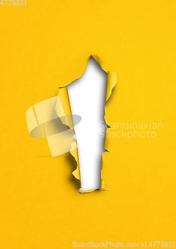 Image of Yellow torn paper with hole