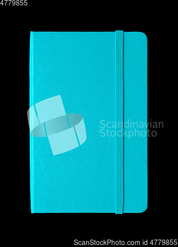 Image of Aqua blue closed notebook isolated on black