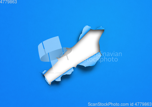 Image of Blue torn paper with hole
