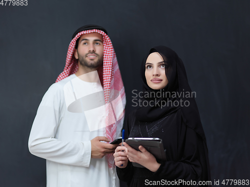 Image of Young muslim business couple using technology devices