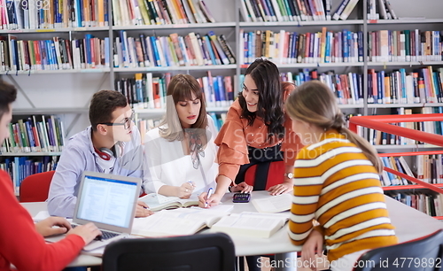 Image of students group working on school project together on tablet computer at modern university